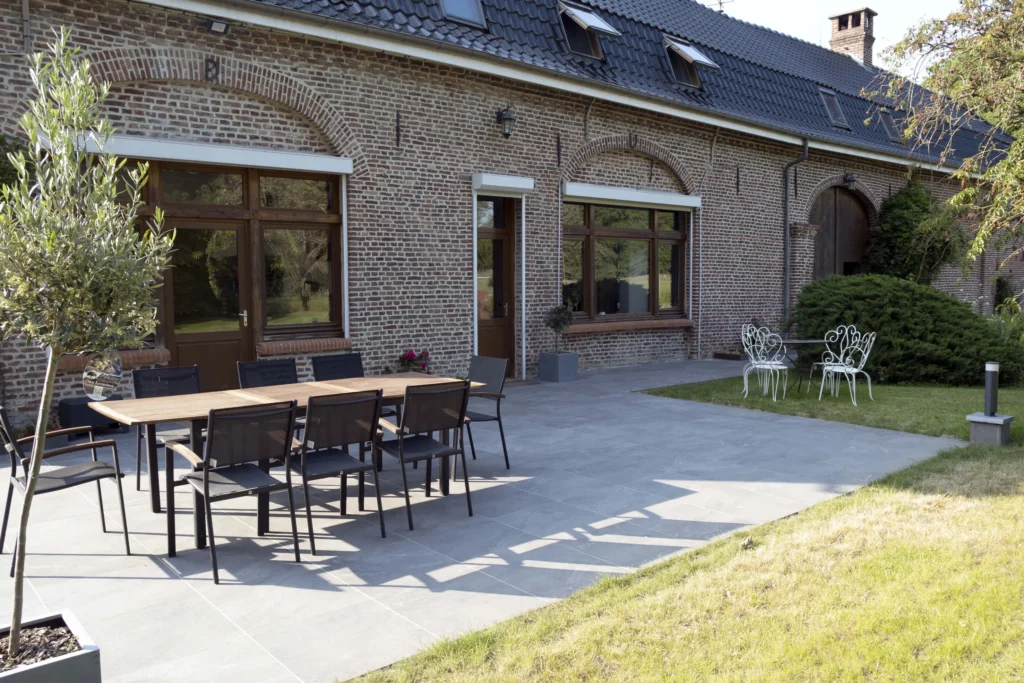 Terrasse en grès ceram grise avec massifs intégrés.