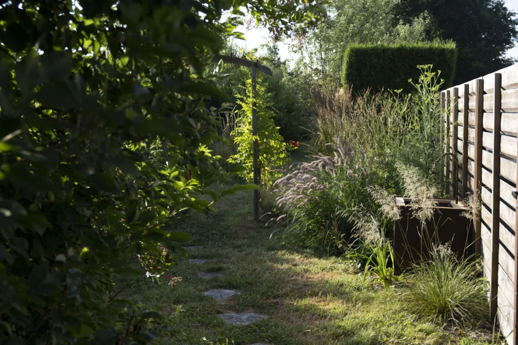 Un jardin avec une arche et des pas japonais qui invitent à la promenade